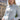 Woman wearing a light blue structured linen coat standing in front of the Eiffel Tower.